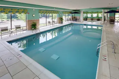 a large pool in a hotel with tables and chairs at Hampton Inn & Suites Columbus Polaris in Columbus
