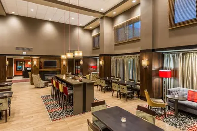 a hotel lobby with tables and chairs and a bar at Hampton Inn & Suites Columbus Polaris in Columbus