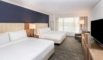 a hotel room with two beds and a flat screen tv at Hilton Columbus/Polaris in Columbus