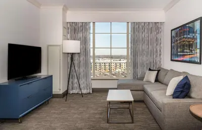 a living room with a couch and a tv at Hilton Columbus/Polaris in Columbus