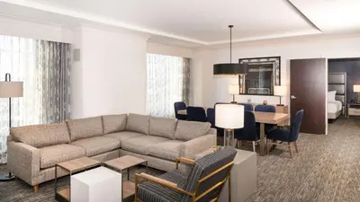 a living room with a couch and a dining room at Hilton Columbus/Polaris in Columbus
