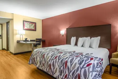 a hotel room with a large bed and a desk at Red Roof Inn Perrysburg in Perrysburg