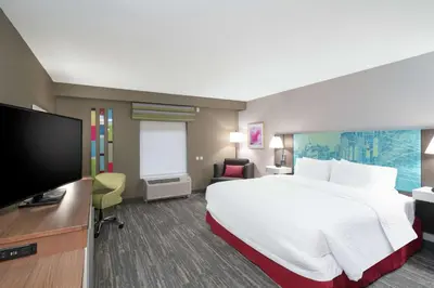 a hotel room with a large bed and a flat screen tv at Hampton Inn Weston, WV in Weston