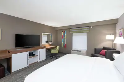 a hotel room with a bed and a desk with a television at Hampton Inn Weston, WV in Weston