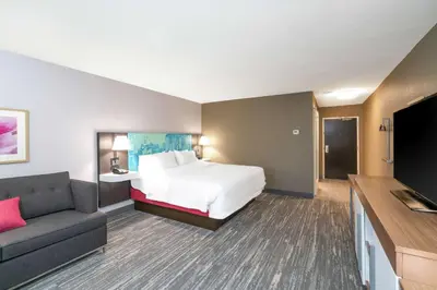 a hotel room with a bed and a couch at Hampton Inn Weston, WV in Weston