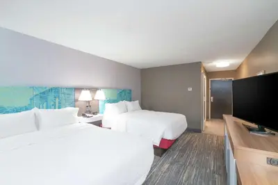 a hotel room with two beds and a flat screen tv at Hampton Inn Weston, WV in Weston