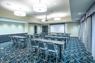 a conference room with tables and chairs and a whiteboard at Hampton Inn Weston, WV in Weston