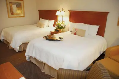 a hotel room with two beds with flowers on them at Hampton Inn Columbus-International Airport in Gahanna