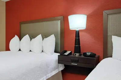 a hotel room with a bed with a lamp and a phone at Hampton Inn Columbus-International Airport in Gahanna
