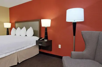 a hotel room with a bed and a chair at Hampton Inn Columbus-International Airport in Gahanna