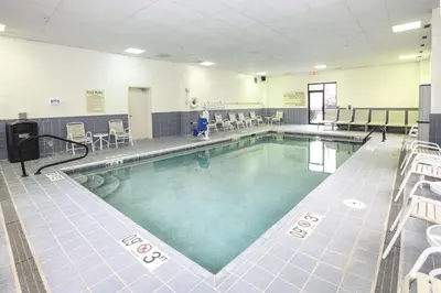 a large swimming pool in a gym with tables and chairs at Hampton Inn Cincinnati Eastgate in Eastgate