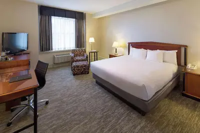 a hotel room with a bed and a desk and a television at Hilton Cincinnati Netherland Plaza in Cincinnati