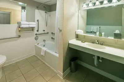 a bathroom with a sink and a tub and a toilet at Hilton Cincinnati Netherland Plaza in Cincinnati