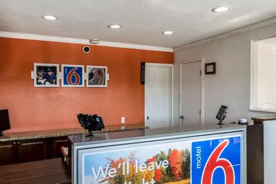 a tv screen in a room with an orange wall at Motel 6 Florence, KY - Cincinnati Airport in Florence