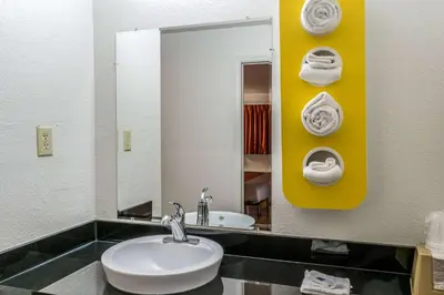 a bathroom with a sink and a mirror and towels at Motel 6 Florence, KY - Cincinnati Airport in Florence
