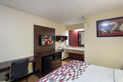 a hotel room with a bed and a desk and a sink at Red Roof Inn Cincinnati East - Beechmont in Cherry Grove