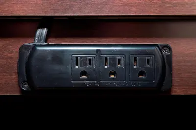 a black electrical outlet on a wooden table at Red Roof Inn Cincinnati East - Beechmont in Cherry Grove