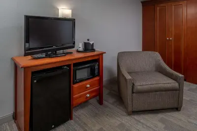 a room with a tv and a chair and a chair at Hampton Inn Charleston Downtown in Charleston