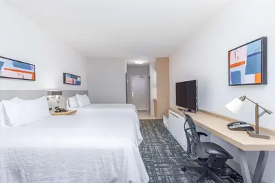 a hotel room with a bed and a desk with a computer at Hilton Garden Inn Cincinnati/Sharonville in Sharonville