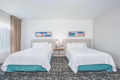 two beds in a hotel room with white walls at Hilton Garden Inn Cincinnati/Sharonville in Sharonville