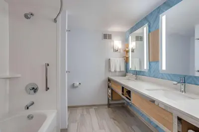a bathroom with two sinks and a tub and a mirror at Hilton Garden Inn Cincinnati/Sharonville in Sharonville