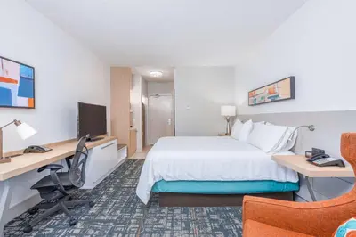 a hotel room with a bed and a desk and a computer at Hilton Garden Inn Cincinnati/Sharonville in Sharonville