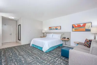 a hotel room with a bed and a couch at Hilton Garden Inn Cincinnati/Sharonville in Sharonville