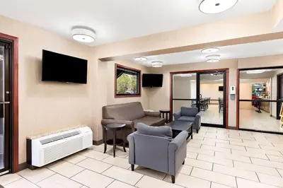 a waiting room with chairs and a couch and a tv at Quality Inn Middleburg Heights near Cleveland Airport in Middleburg Heights