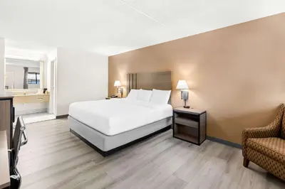 a hotel room with a bed and a chair at Quality Inn Middleburg Heights near Cleveland Airport in Middleburg Heights