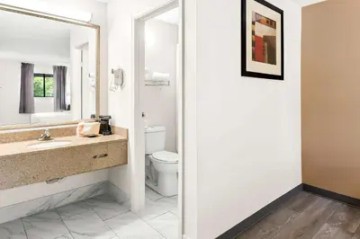 a bathroom with a sink and a toilet and a mirror at Quality Inn Middleburg Heights near Cleveland Airport in Middleburg Heights