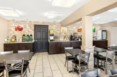 a restaurant with tables and chairs and a bar at Quality Inn Middleburg Heights near Cleveland Airport in Middleburg Heights