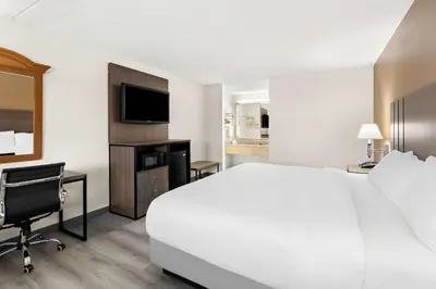 a hotel room with a bed and a desk and a television at Quality Inn Middleburg Heights near Cleveland Airport in Middleburg Heights