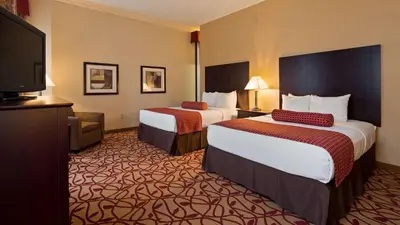 a hotel room with two beds and a flat screen tv at Best Western Park Hotel in Warren