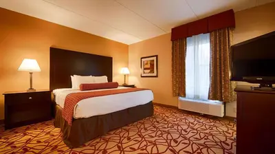 a hotel room with a bed and a flat screen tv at Best Western Park Hotel in Warren