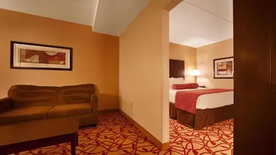 a hotel room with a bed and a chair at Best Western Park Hotel in Warren