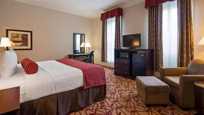 a hotel room with a bed and a chair at Best Western Park Hotel in Warren