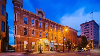 a large brick building on a city street at night at Best Western Park Hotel in Warren