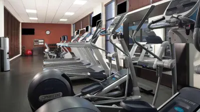 a gym with rows of treadmills and machines at Hampton Inn Charleston-Southridge in Charleston
