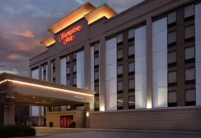 a hotel with a sign on the front of a building at Hampton Inn Charleston-Southridge in Charleston