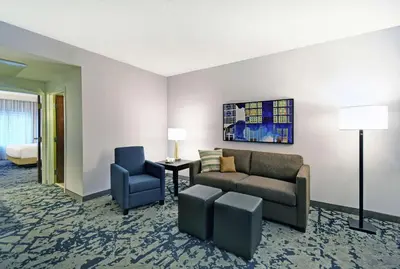 a living room with a couch and a chair at Embassy Suites Charleston in Charleston