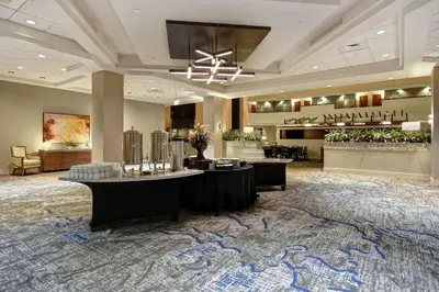 a hotel lobby with a reception desk and a salon at Embassy Suites Charleston in Charleston