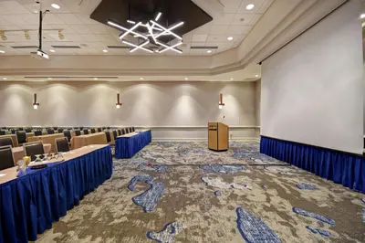 a conference room with tables and chairs and a whiteboard at Embassy Suites Charleston in Charleston