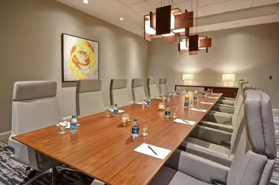 a conference room with a long wooden table and chairs at Embassy Suites Charleston in Charleston