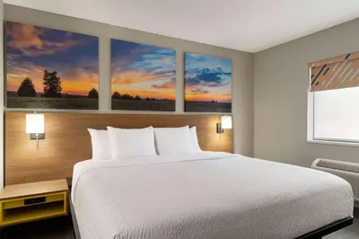 a bedroom with a bed and three paintings on the wall at Days Inn by Wyndham Washington Court House in Washington Court House