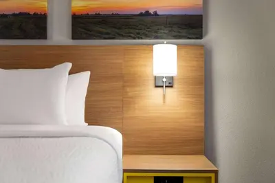 a bedroom with a bed and a lamp on a headboard at Days Inn by Wyndham Washington Court House in Washington Court House