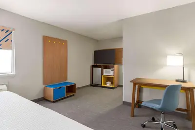 a hotel room with a desk and a bed and a desk and chair at Days Inn by Wyndham Washington Court House in Washington Court House