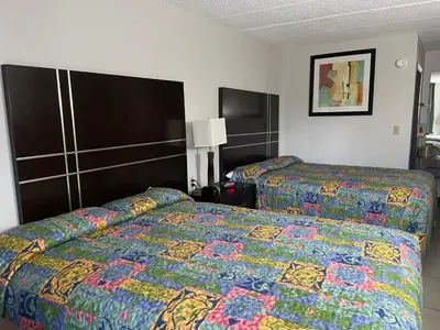 a hotel room with two beds with colorful blankets at Deerfield Inn in Xenia
