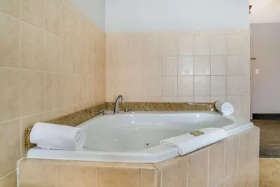 a bathroom with a bath tub with towels on it at Country Inn & Suites by Radisson, Rossford - Toledo South in Rossford
