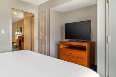 a bedroom with a tv on a dresser with a bed at Country Inn & Suites by Radisson, Rossford - Toledo South in Rossford