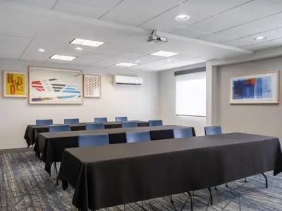 a conference room with black tables and blue chairs at Holiday Inn Express Toledo North by IHG in Toledo